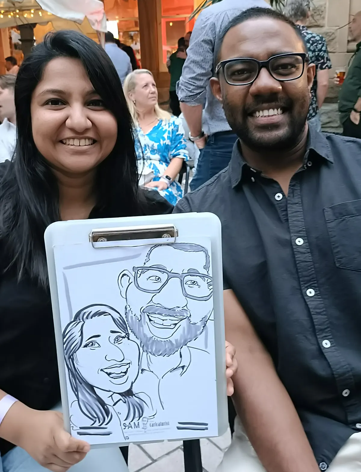 Two colleagues holding up their caricatures
