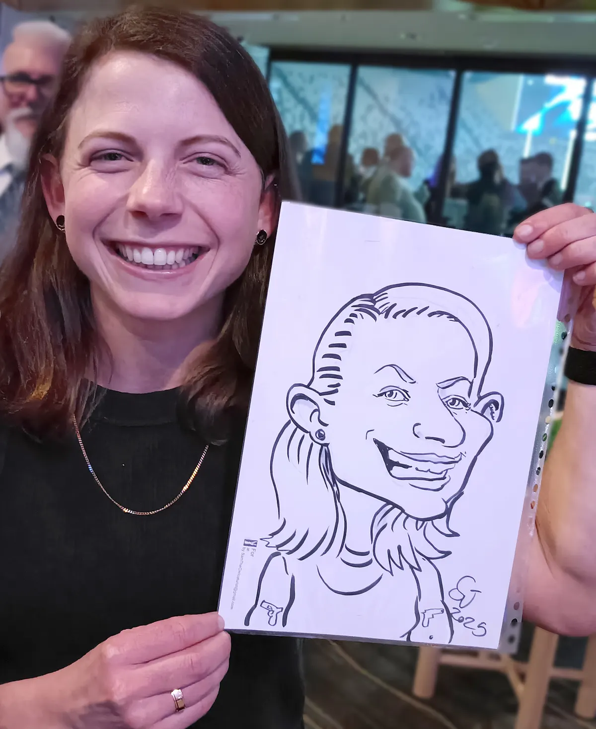 Smiling woman holding up her pen and ink caricature