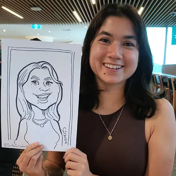 Corporate guest holding up the caricature Sam drew of her