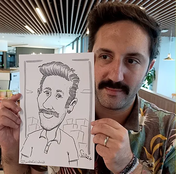 Corporate guest holding up a caricature next to his face